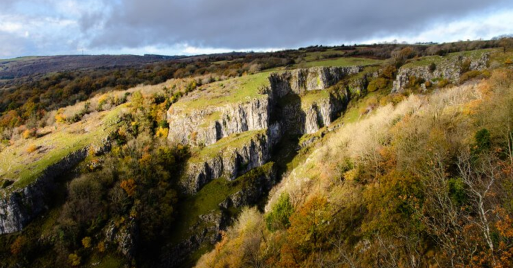 Things to do in Wells shown through Ebbor Gorge near Wells with limestone cliffs, marked walking trails, open greenery, and natural scenery
